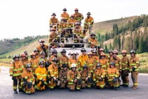 east grand volunteer firefighters in bunker gear posed for professional group photo in front of fire truck